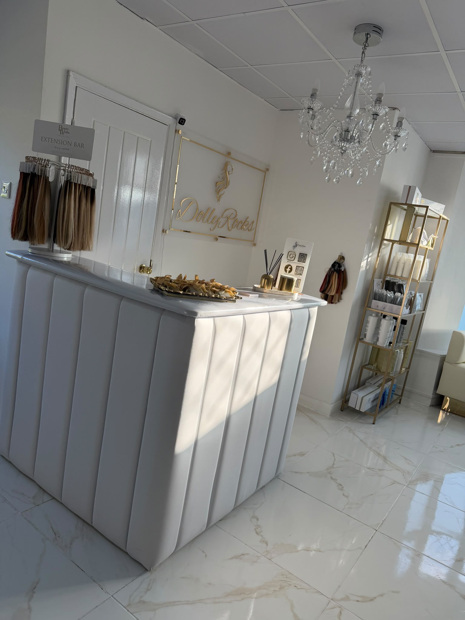 Reception desk at Dolly Rocks with the salon's gold signage and extension bar