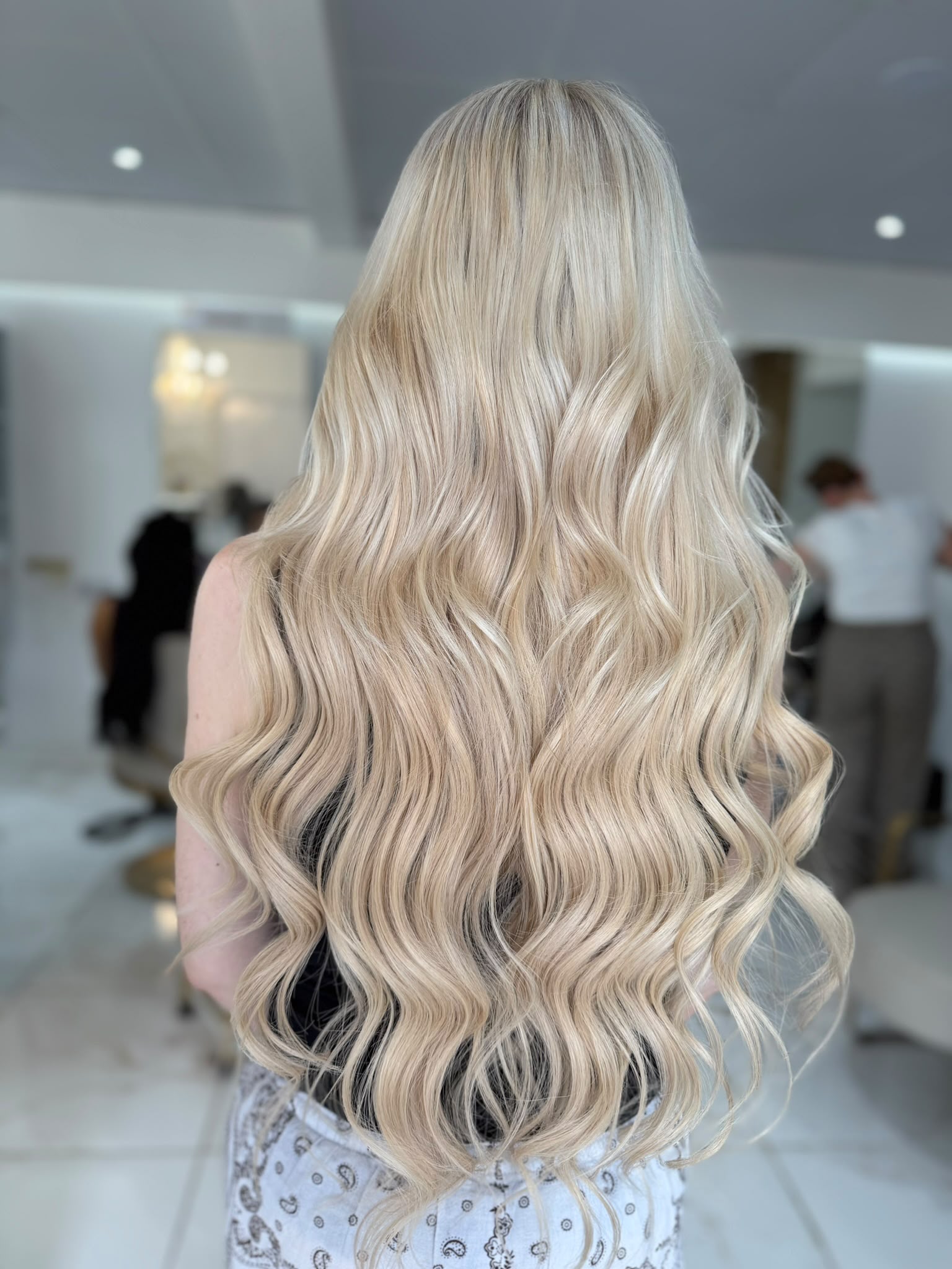 Long wavy blonde hair extensions styled at Dolly Rocks